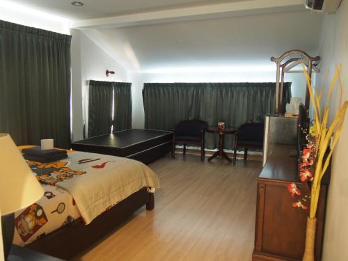 a bedroom with a bed and a desk and a table at Nong Nuey Rooms in Ko Samed