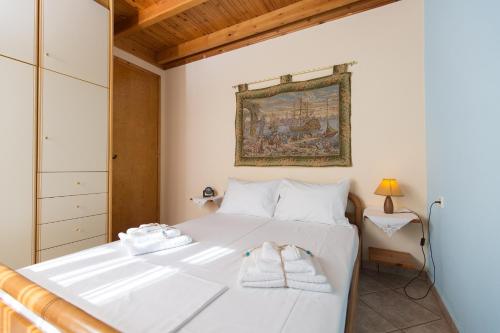 a bedroom with a white bed with towels on it at Villa Heavens Knights with private pool in Magoúla