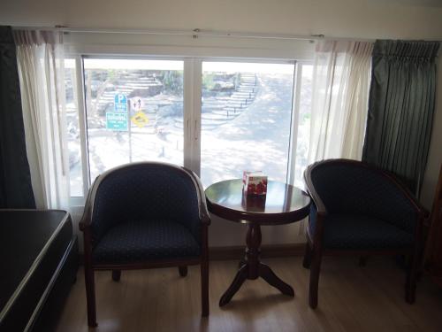 a room with two chairs and a table and a window at Nong Nuey Rooms in Ko Samed