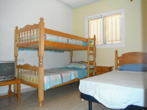 プラヤ・フラメンカにあるApartments Zeniamar ZM005のベッドルーム1室(二段ベッド2台、テレビ付)