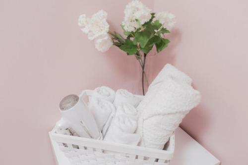 a basket with towels and a vase of flowers at MJ Stay 2 in Seoul