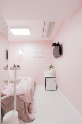 a white room with a bed and a table at MJ Stay 2 in Seoul