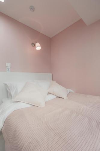 a white bedroom with a bed with white sheets and pillows at MJ Stay 2 in Seoul