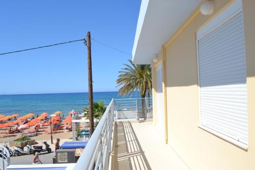 a balcony with a view of the beach with umbrellas at 4S Beach Superior Apartments in Stalida