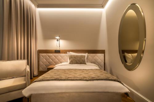 a bedroom with a bed and a mirror at Hotel Vilnia in Vilnius