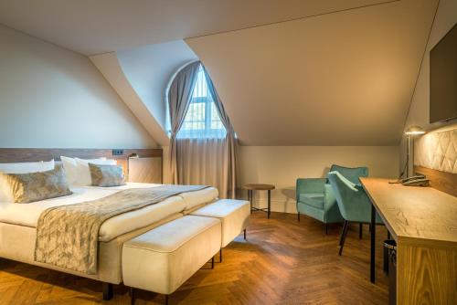 a bedroom with a bed and a window and a table at Hotel Vilnia in Vilnius