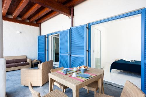 a living room with blue doors and a table and chairs at NerOssidiana in Acquacalda