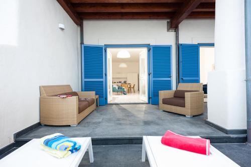 a room with blue doors and chairs and tables at NerOssidiana in Acquacalda