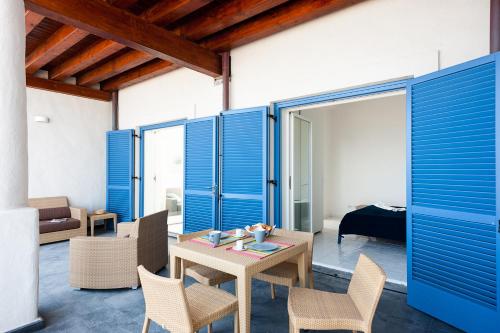 a room with blue shutters and a table and chairs at NerOssidiana in Acquacalda
