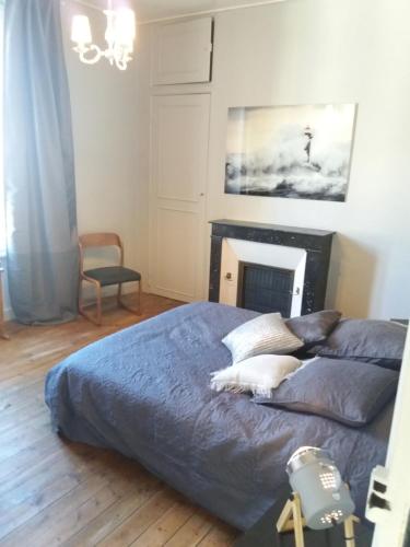 サン・マロにあるBel appartement vue mer Saint-Maloのベッドルーム1室(青いシーツと暖炉付きのベッド1台付)