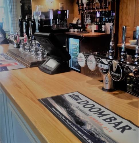 a bar with a sign on top of a counter at The Royal Inn in St Austell