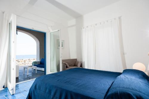 a bedroom with a blue bed and a view of the ocean at NerOssidiana in Acquacalda