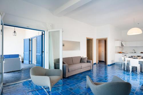 a living room with a couch and chairs and a kitchen at NerOssidiana in Acquacalda