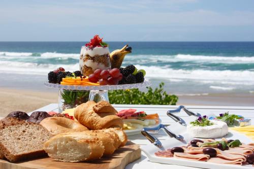 a table with a cake and bread on the beach at Escape to the Beach in Wilderness