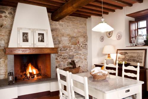 a living room with a fireplace and a table and chairs at Romitorio di Serelle in Barberino di Val dʼElsa