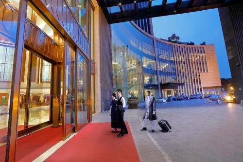 a group of people walking down a street with luggage at Dongguan Kande International Hotel in Dongguan