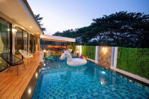 una piscina con fideos inflables en una casa en GetZleep PoolVilla en Sattahip
