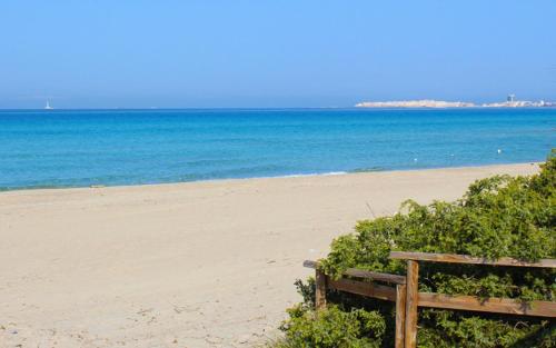 a bench on a beach with the ocean in the background at Casa Direttamente sul mare in Marina di Mancaversa