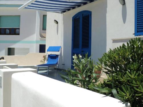 a blue chair sitting outside of a house at Casa Direttamente sul mare in Marina di Mancaversa