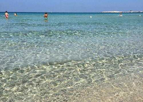 a group of people in the water at the beach at Casa Direttamente sul mare in Marina di Mancaversa
