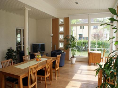 Una sala de estar con una mesa y sillas de madera. en Hotel Wictoria, en Mariestad