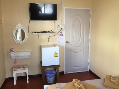 a room with a white door and a tv on the wall at Anya House in Thongsala