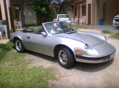 a silver convertible car parked in a driveway at POUSADA TAQUARAS in Cassino