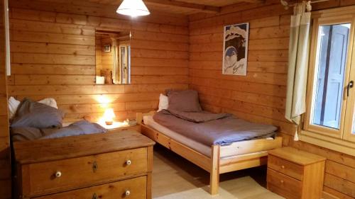 a room with two beds in a log cabin at Chalet Beauroc in Morgins