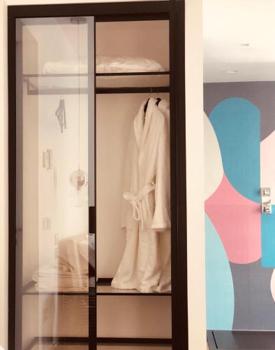 a glass cabinet with a white coat in it at HOTIDAY Room Collection - Olbia Wallure in Olbia