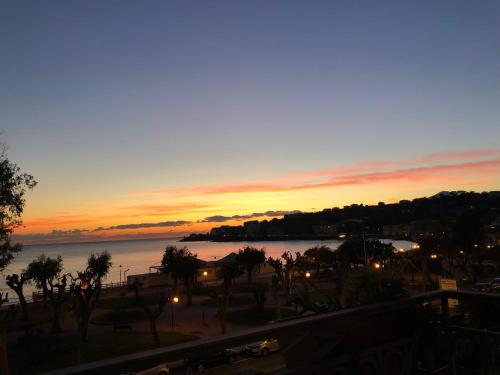 a sunset over a body of water with a city at Hotel Pisacane in Sapri