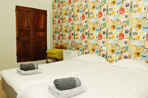 two beds in a room with a wall covered in photos at Auberge Le Romarin in Valgorge
