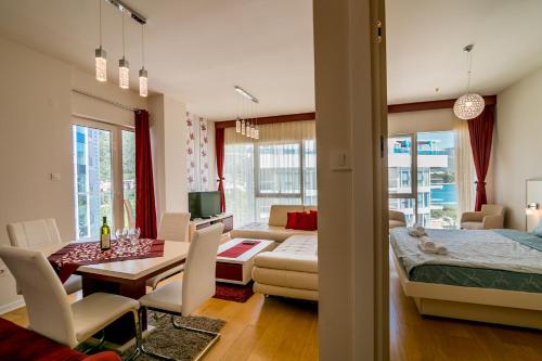 a living room with a bed and a dining room at Apartments Menuet in Budva
