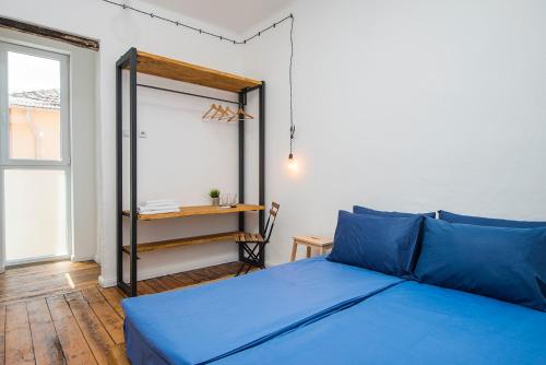 a bedroom with a blue bed and a window at Generaator Sofia in Sofia