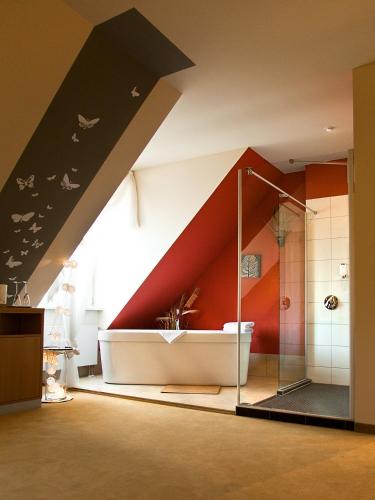 a room with a shower with a red wall at Hotel Stempferhof in Gößweinstein