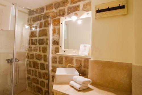 a bathroom with a shower and a sink and a mirror at Pietra Mare Apartments in Petrovac na Moru