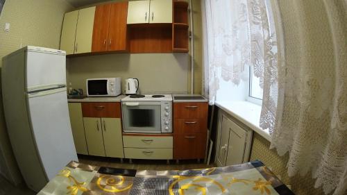 ノヴォシビルスクにあるАпартаменты на Блюхера 43の小さなキッチン(冷蔵庫、電子レンジ付)