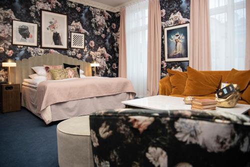 a bedroom with a bed and a couch and a table at The Vault Hotel, WorldHotels Crafted in Helsingborg