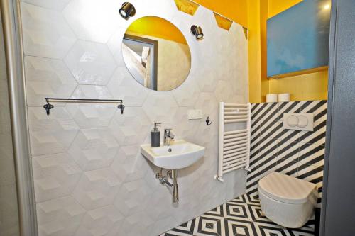 a bathroom with a sink and a mirror at Grand Apartments - Superior Loft Apartment in Sopot