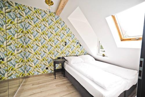 ソポトにあるGrand Apartments - Superior Loft Apartmentのベッド1台と壁画が備わる小さな客室です。