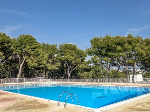 une piscine avec des arbres en arrière-plan dans l'établissement Apartment Athéna Résidence-1 by Interhome, à Bandol