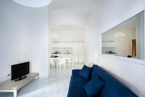 a living room with a blue couch and a tv at NerOssidiana in Acquacalda