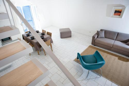 a living room with a blue chair and a couch at NerOssidiana in Acquacalda