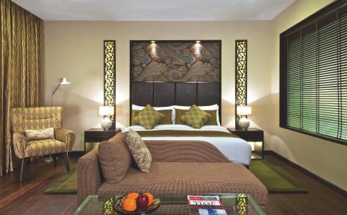 - une chambre avec un lit, un canapé et une chaise dans l'établissement Vivanta Dal View, à Srinagar