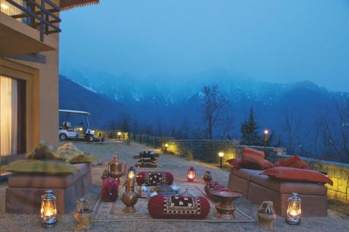 a living room with couches and candles on a patio at Taj Dal View Srinagar in Srinagar