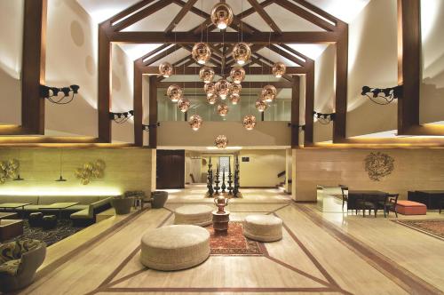 a large lobby with a chandelier and tables and chairs at Vivanta Dal View in Srinagar