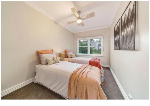 a bedroom with two beds and a ceiling fan at Gracemont Boutique Accommodation in Healesville