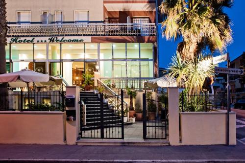 ein Gebäude mit einer Treppe vor einem Geschäft in der Unterkunft Hotel Welcome - All inclusive in San Benedetto del Tronto