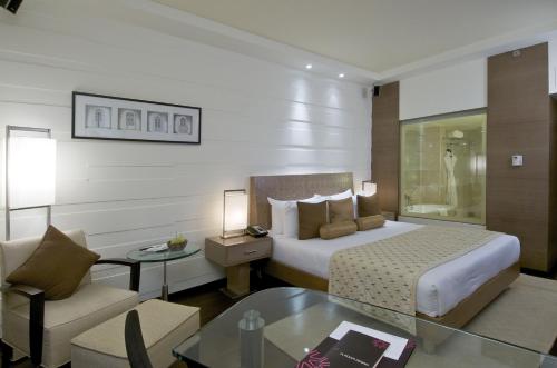 a hotel room with a bed and a couch and a table at Vivanta Goa, Panaji in Panaji