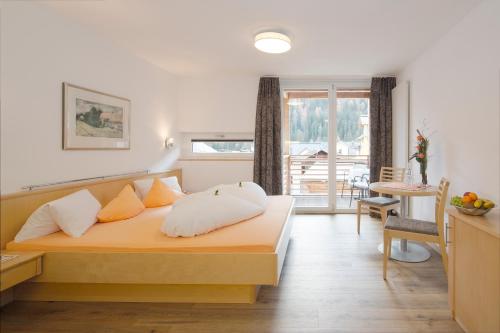 a bedroom with a bed and a living room at Apart Hotel Garni Alvetern in Samnaun