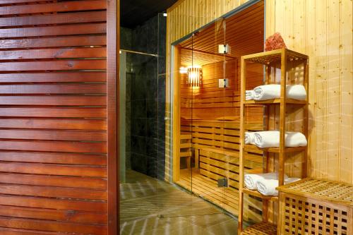 eine Sauna mit Holzwänden und Handtüchern auf Regalen in der Unterkunft Focus Hotel Premium Inowrocław in Inowrocław